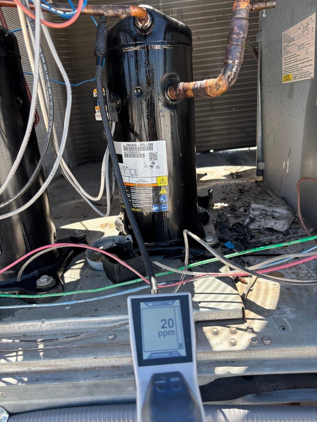 Refrigerant leak detector showing 20 PPM reading at compressor copper fitting during AC repair in Vail, Arizona
