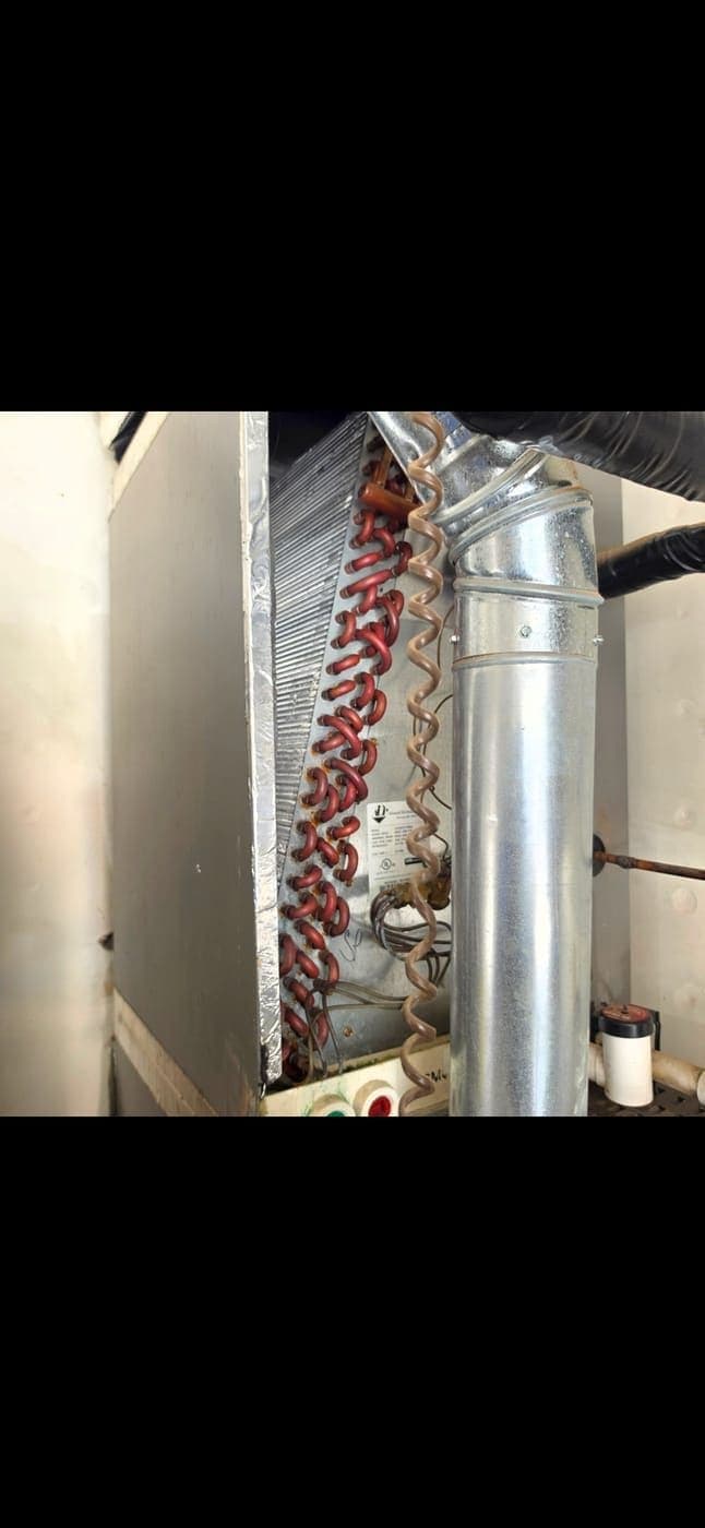 The same evaporator coil after fully thawing, revealing the exposed copper U-bend tubes with light surface corrosion